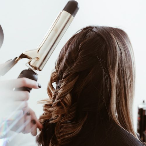 person holding gray hair curler